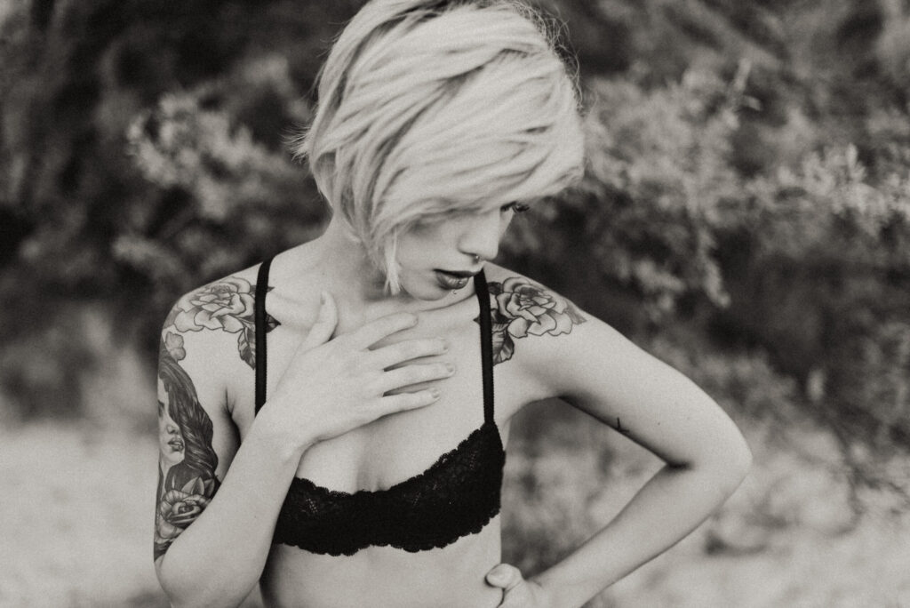 Woman with tattoos in black lace bra