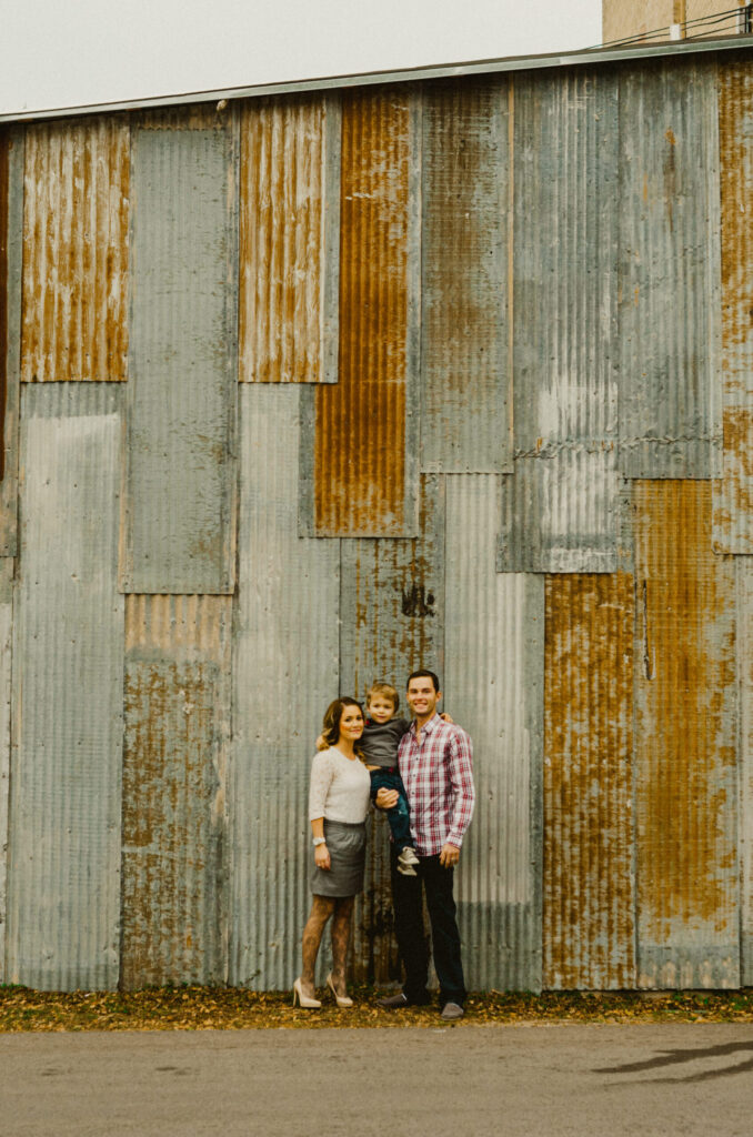 Family standing by rustic metal wall