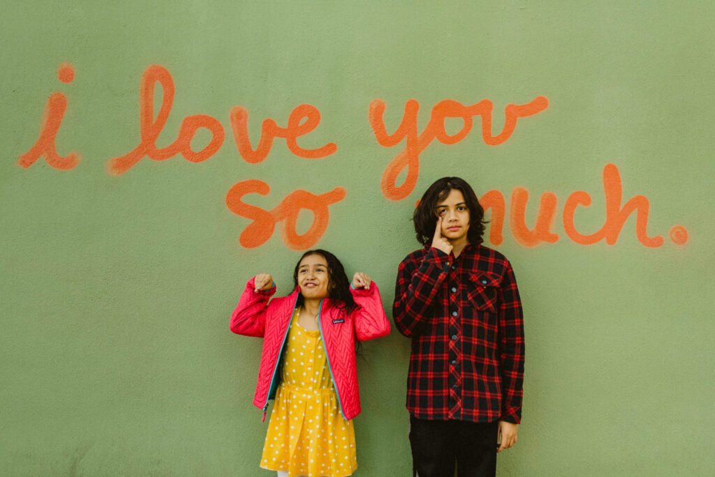 Kids standing by 'I love you so much' mural.