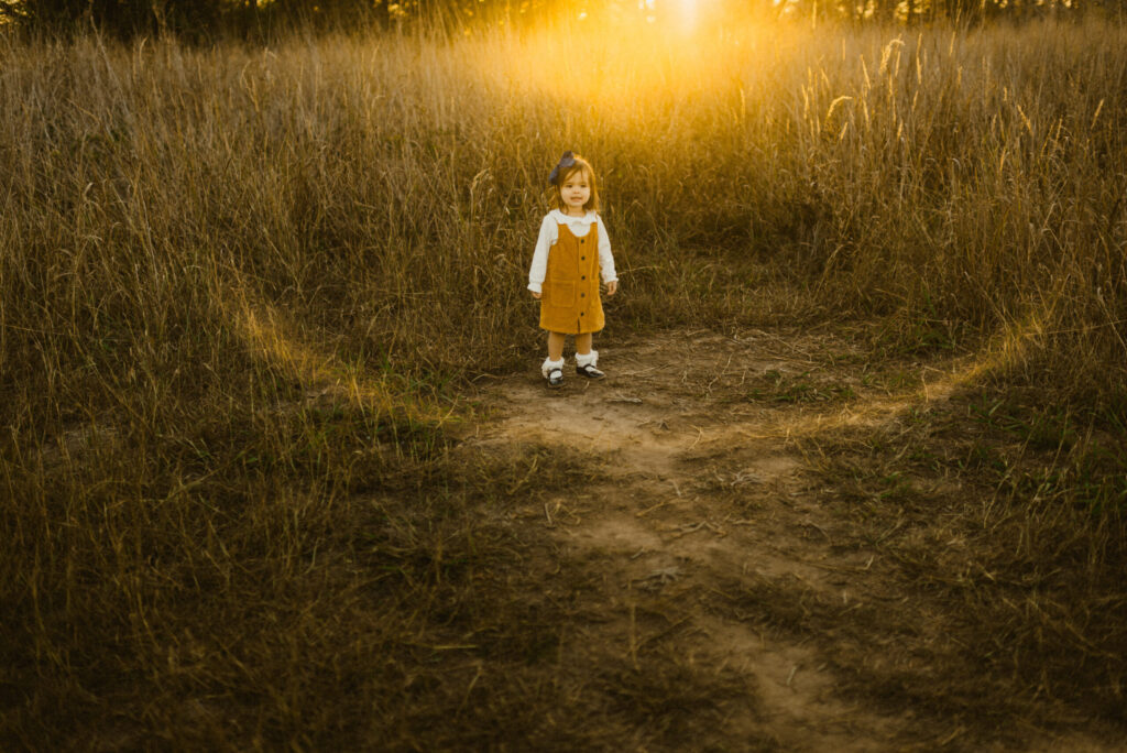 Child in field at sunset