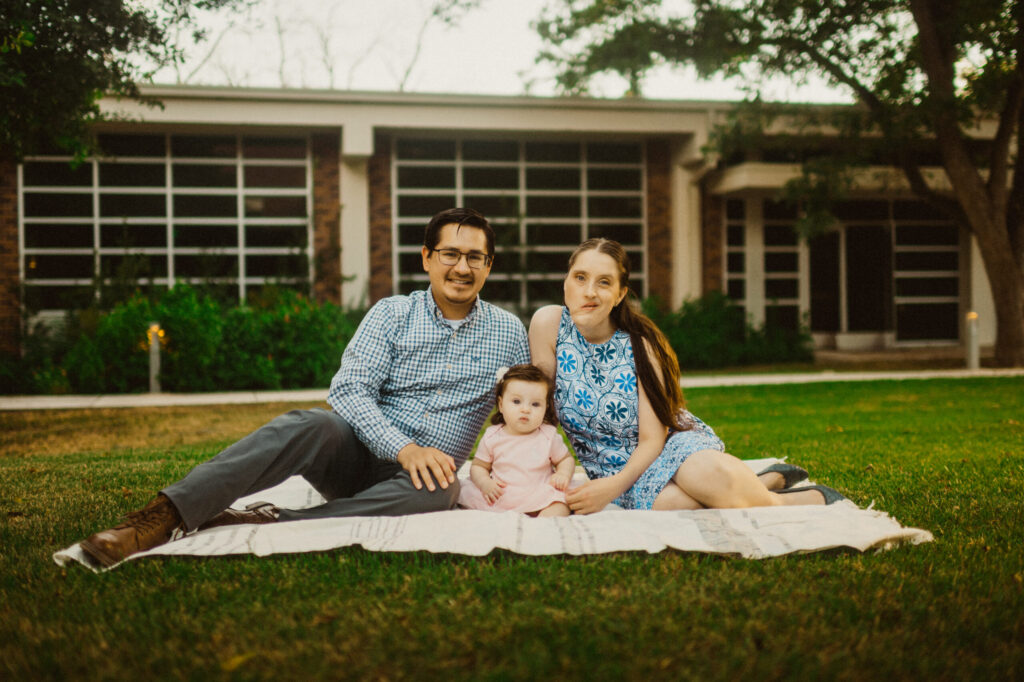 Family sitting on blanket outside building